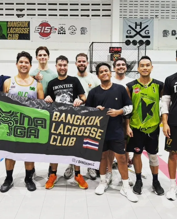 Club members holding the green Naga banner at an indoor facility